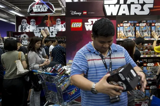 Customers pick new toys from the upcoming film “Star Wars: The Force Awakens” on “Force Friday” in Hong Kong, China, September 4, 2015. (Photo by Tyrone Siu/Reuters)