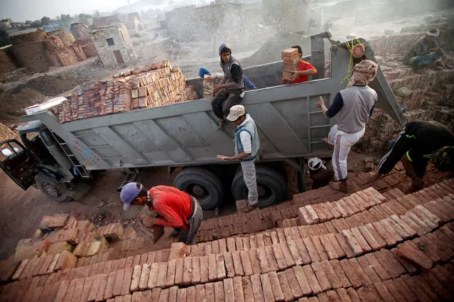 Labourers load mud bricks onto a truck at a brick factory on the outskirt of Sanaa, Yemen May 29, 2016. (Photo by Mohamed al-Sayaghi/Reuters)