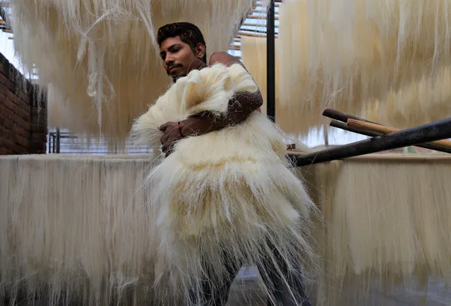 A man carries strands of vermicelli, a specialty eaten during the Muslim holy fasting month of Ramadan, to dry at a factory during a nationwide lockdown to slow the spreading of the coronavirus disease (COVID-19), in Prayagraj, India, April 23, 2020. (Photo by Jitendra Prakash/Reuters)