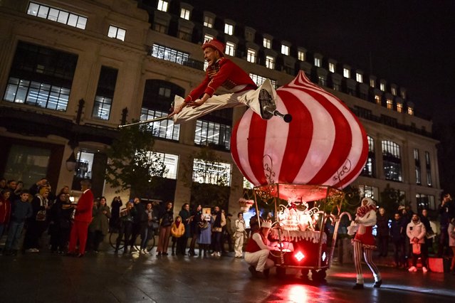 Acrobats perform during the ceremony of Samaritaine's Christmas window displays revealing in Paris on November 8, 2023. Since 1869, La Samaritaine, with its boldly-lettered Art Nouveau facade looming over the Seine River and the Pont Neuf bridge, had been a reliable fixture in the city landscape. But due to major building safety concerns and some dubious business decisions, the nineteenth-century store so dear to many Parisians closed its doors in 2005. Fifteen years after its closure, La Samaritaine re-opened in June 2021 after an extensive revamp. (Photo by ABACA Press/Rex Features/Shutterstock)