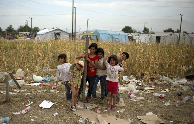 Migrant children react while being photographed as they wait to enter a camp for registration procedure after crossing the Macedonian-Greek border near Gevgelija, Macedonia, September 6, 2015. (Photo by Stoyan Nenov/Reuters)