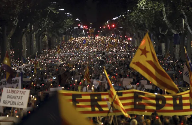 People gather to protest against the National Court's decision to imprison civil society leaders without bail, in Barcelona, Spain, Tuesday, October 17, 2017. Spain's top court also ruled Tuesday that a recent independence referendum in Catalonia was unconstitutional, a day after a Madrid judge provisionally jailed two Catalan independence leaders, Jordi Sanchez and Jordi Cuixart, in a sedition probe. (Photo by Emilio Morenatti/AP Photo)