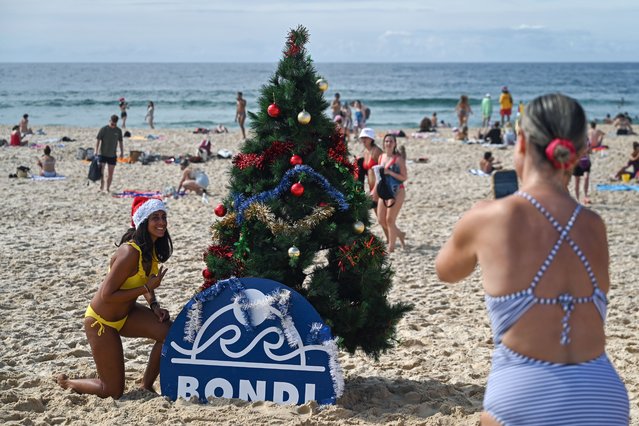 People take photos with a Christmas tree as they celebrate Christmas Day at Bondi Beach in Sydney, Australia on December 25, 2023. (Photo by Steven Saphore/EPA/EFE/Rex Features/Shutterstock)
