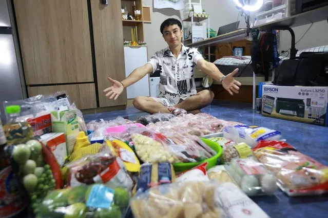 TikTok star Phattaradej “Top” Luechai, 29, who became famous for sharing his extreme frugal monthly meal prep for himself and his partner due to inflation, poses next to stored food for one month to illustrate his tight budget grocery shopping under $109 on his channel, in Samut Prakan province, Thailand on August 29, 2022. (Photo by Kwang Jiraporn Kuhakan/Reuters)