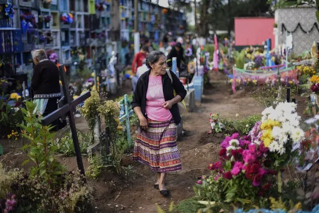 A man adorns a grave at the municipal cemetery of Villa Nueva, 25 km south of Guatemala City, during the celebration of All Saints Day on November 1, 2017. (Photo by Johan Ordonez/AFP Photo)