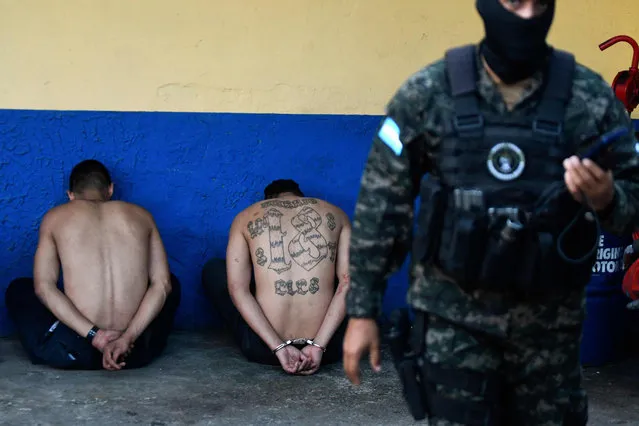 Members of the Barrio 18 gang are presented to the press by the Military Police of Public Order (PMOP), captured during confrontations in Tegucigalpa on October 18, 2022. The PMOP seized the gang members' R-15 rifles, ammunition, money, police uniforms, and radios. (Photo by Orlando Sierra/AFP Photo)