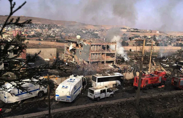 Smoke still rises from the scene after Kurdish militants attacked a police checkpoint in Cizre, southeast Turkey, Friday, August 26, 2016, with an explosives-laden truck, killing several police officers and wounding dozens more, according to reports from the state-run Anadolu news agency. The attack struck the checkpoint some 50 meters (yards) from a main police station near the town of Cizre, in the mainly-Kurdish Sirnak province that borders Syria. Turkish authorities have put a temporary ban on distribution of images relating to Friday's Cizre attack within Turkey. (Photo by DHA via AP Photo)