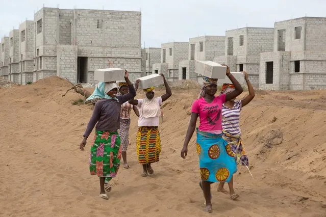 Women carry bricks at the construction site of real estate company Sipim in Grand Bassam, Ivory Coast, September 15, 2015. They are paid 25 West African francs (about $0.04) for each brick they carry. From Abidjan's packed airport arrivals hall to the buildings mushrooming across the capital, Ivory Coast is booming, a rare African bright spot as the worldâ€™s biggest cocoa producer bounces back from a 2011 civil war. (Photo by Joe Penney/Reuters)