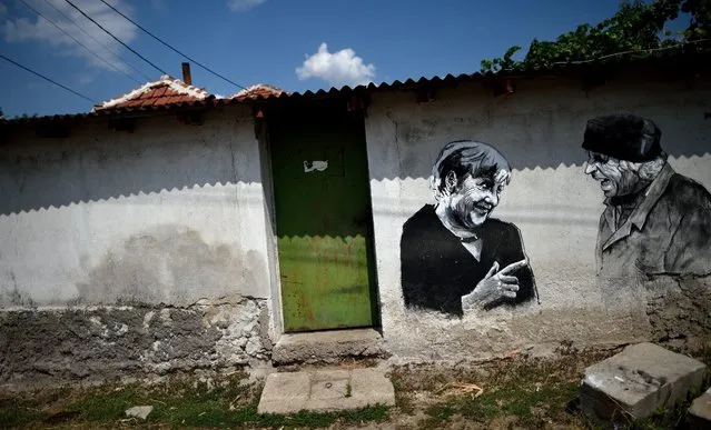 A photo made available on 31 August 2016 shows a mural depicting local man Kancho and German Chancellor Angela Merkel, painted during a mural festival on a wall in the village of Staro Zhelezare some 14km from Sofia, Bulgaria, 30 August 2016.The project was initiated by the artistic duo Katarzyna and Ventzi Piryankova living permanently in Poznan, Poland. The festival is titled “Village of personalities / Art for Social Change”. The project started in 2013 and there have been created about 53 paintings in the village, representing local people in company of celebrities from politics and culture. (Photo by Vassil Donev/EPA)