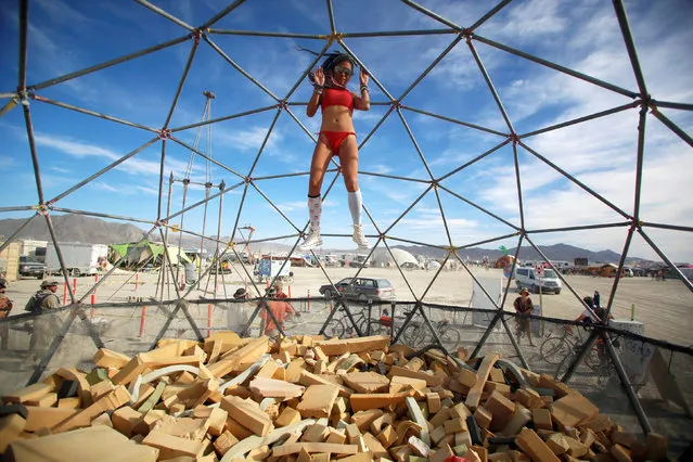 Lulu, her Playa name, falls into a foam pit as approximately 70,000 people from all over the world gather for the 30th annual Burning Man arts and music festival in the Black Rock Desert of Nevada, U.S. September 1, 2016. (Photo by Jim Urquhart/Reuters)