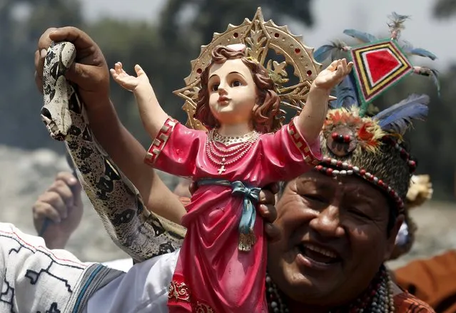 Peruvian shamans holding a figure of a Nino Jesus (Child Jesus) and a snake perform a ritual at the Rimac river to fight the negative effects of the Nino weather phenomena over Nature, in Lima, Peru October 1, 2015. (Photo by Mariana Bazo/Reuters)