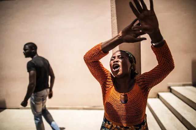 A distressed Gabonese woman reacts at the Libreville Magistrate Court on September 6, 2016, while she waits, with other relatives, to hear about the release of young men arrested during a wave of unrest that followed the announcement of the results of the Presidential election. Pressure mounted on Gabon's President Ali Bongo on September 6 over his disputed poll victory as his justice minister resigned over the results and former colonial ruler France suggested a recount. Some 800 people have been arrested in recent days in the capital, with the authorities accusing them of looting, while lawyers say they are being held in “deplorable” conditions. (Photo by Marco Longari/AFP Photo)