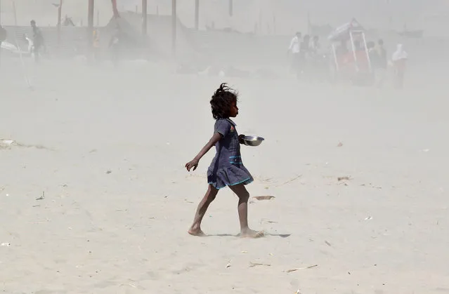 A girl walks amidst a dust storm on the banks of the Ganges river in Allahabad, India, February 24, 2017. (Photo by Jitendra Prakash/Reuters)