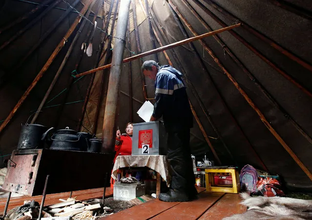 A herder casts his ballot during early voting in the elections to the lower house of parliament in remote areas at a reindeer camping ground on the banks of the Barents Sea, north of Naryan-Mar in Nenets region, Russia September 12, 2016. (Photo by Sergei Karpukhin/Reuters)