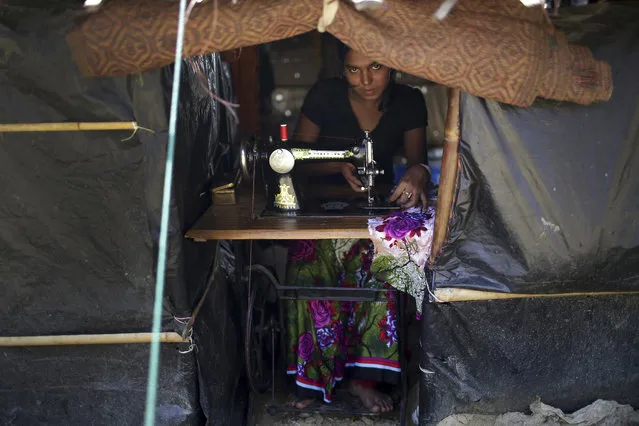 A Rohingya Muslim woman works on her sewing machine inside her tent at Kutupalong refugee camp on Tuesday, November 28, 2017, in Bangladesh. Since late August, more than 620,000 Rohingya have fled Myanmar's Rakhine state into neighboring Bangladesh, where they are living in squalid refugee camps. (Photo by Wong Maye-E/AP Photo)