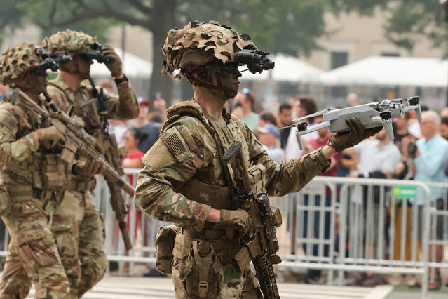 A soldier holds a drone while marching on June 14, 2025. (Photo by Jonathan Ernst/Reuters)