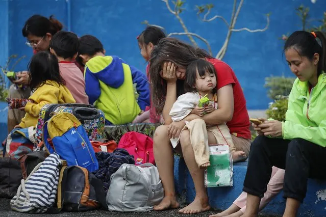 Survivors take a rest at police station after a landslide hit the campsite in Batang Kali, state of Selangor, Malaysia, 16 December 2022. A landslide at a tourist campground in Malaysia left 16 people dead. According to the authorities, others were feared buried at the site at an organic farm outside the capital of Kuala Lumpur. (Photo by Fazry Ismail/EPA/EFE)