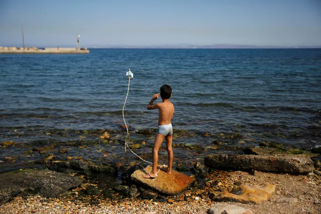 A Syrian boy plays next to the sea at the Souda municipality-run camp for refugees and migrants, on the island of Chios, Greece, September 7, 2016. (Photo by Alkis Konstantinidis/Reuters)