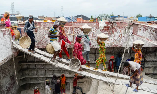 Labourers are seen unloading sand from a cargo ship in Gabtoli, Bangladesh on August 26, 2020. They are earning around $1 for every 30 baskets of sand unloaded from the ship. (Photo by Piyas Biswas/Sopa Inages/Rex Features/Shutterstock)