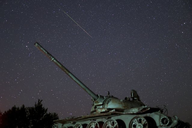 A meteor streaks above a destroyed tank from the 1992-1995 war in Bosnia, during the Perseid meteor shower on Bjelasnica mountain, Bosnia, Tuesday, August 13, 2024. (Photo by Armin Durgut/AP Photo)