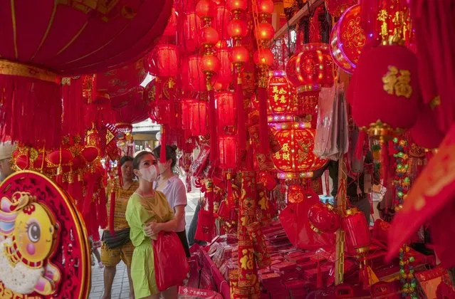 A woman shops for Chinese New Year decorations at a market in the Chinatown area of Jakarta, Indonesia, Thursday, January 12, 2023. People of Chinese descent in the world's most populous Muslim country are preparing to celebrate the lunar New Year Year of the Rabbit on Jan. 22. (Photo by Tatan Syuflana/AP Photo)
