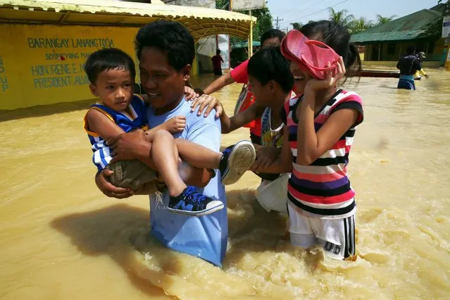 Residents wade in floodwaters brought by typhoon Koppu that battered Candaba town, Pampanga province, north of Manila October 20, 2015. (Photo by Romeo Ranoco/Reuters)