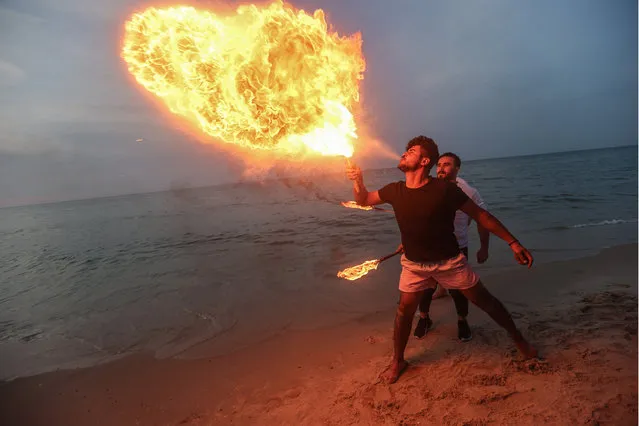 Palestinian youth show their skills in jumping and blowing fire from their mouths on Gaza Beach, Palestine during sunset on January 11, 2023. (Photo by Ahmed Zakot/SOPA Images/Rex Features/Shutterstock)