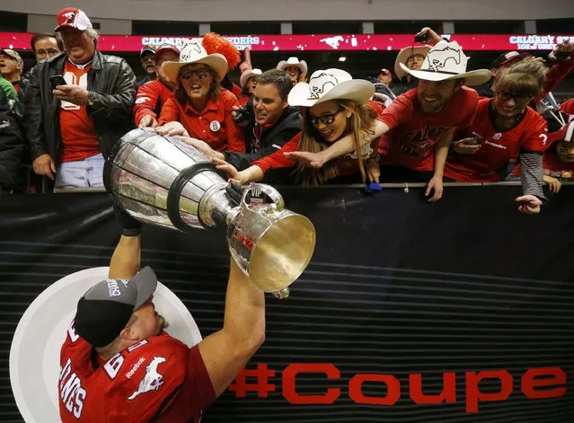 Calgary Stampeders' Brett Jones holds the Grey Cup as he celebrates with fans after his team defeated the Hamilton Tiger Cats in the CFL's 102nd Grey Cup football championship in Vancouver, British Columbia, November 30, 2014. (Photo by Mark Blinch/Reuters)