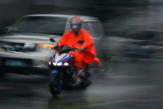 A motorcycle rider wears a raincoat during a downpour in Pasig City, east of Manila, Philippines, 20 October 2020. According to the Philippine Atmospheric Geophysical and Astronomical Services Administration (PAGASA), a Tropical Cyclone Wind Signal (TCWS) Number 2 was raised over several parts of Luzon as Tropical Depression “Pepito” intensified into a tropical storm. (Photo by Mark R. Cristino/EPA/EFE)