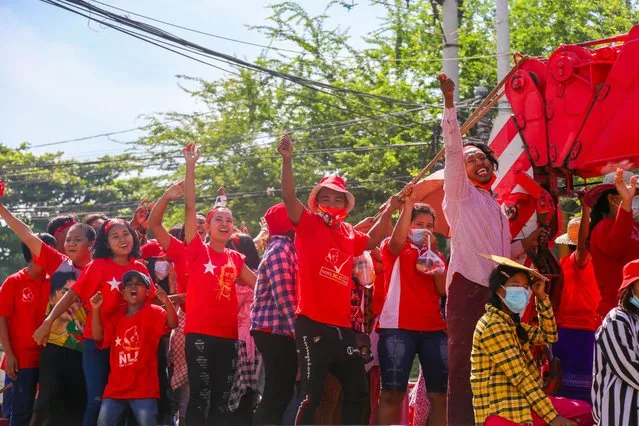 Supporters wearing the party's shirts, shouting on top of a crane truck decorated with flags during the campaign on October 18, 2020. Proponents of the National League For Democracy campaign in Mandalay with a large number of people including 100 crane trucks part of the election campaigns. (Photo by Kaung Zaw Hein/SOPA Images/LightRocket via Getty Images)