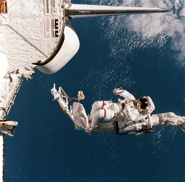In this image provided by NASA, mission specialist Bruce McCandless is shown outside of the Space Shuttle Challenger, February 7, 1984, using a remote manipulator system (RMS) arm and mobile foot restraint (MFR) to experiment with a “cherry picker” concept. (Photo by AP Photo/NASA)