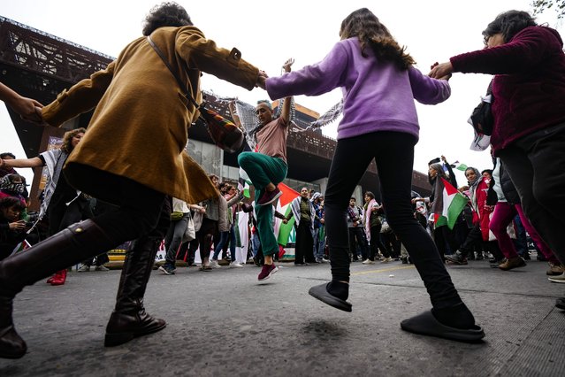 Pro-Palestinian demonstrators perform the Levantine folk dance Dabke during a protest against Israeli attacks on Gaza, in Santiago, Chile, June 8, 2024. (Photo by Esteban Felix/AP Photo)