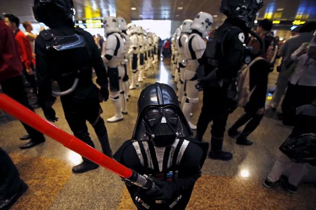 Child "Darth Vader" Wesley Poh, 5, who came with his parents to visit the Star Wars exhibits, leads a group of Stormtrooper actors as they march around at Singapore's Changi Airport November 12, 2015. (Photo by Edgar Su/Reuters)