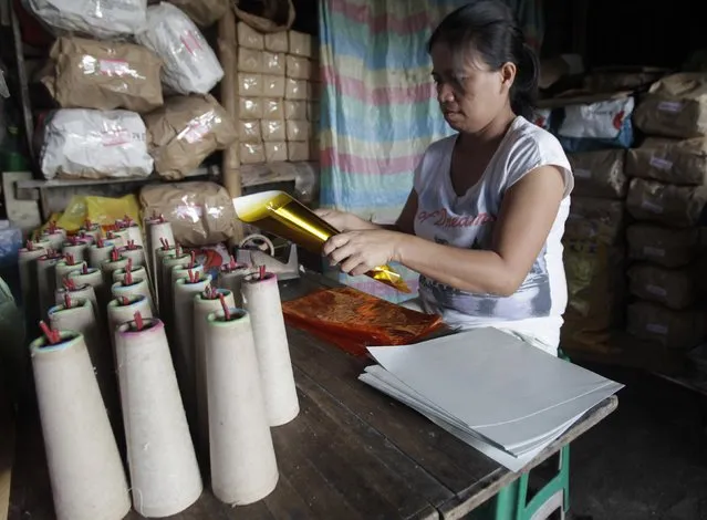 A worker makes pyrotechnics at a makeshift factory in Bocaue town, Bulacan province, north of Manila December 27, 2014. (Photo by Romeo Ranoco/Reuters)