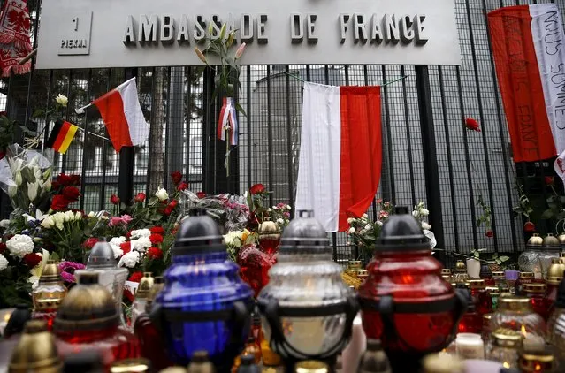 Candles and flowers are seen in front of the French embassy after attacks in Paris on Friday, in Warsaw, Poland November 14, 2015. (Photo by Kacper Pempel/Reuters)