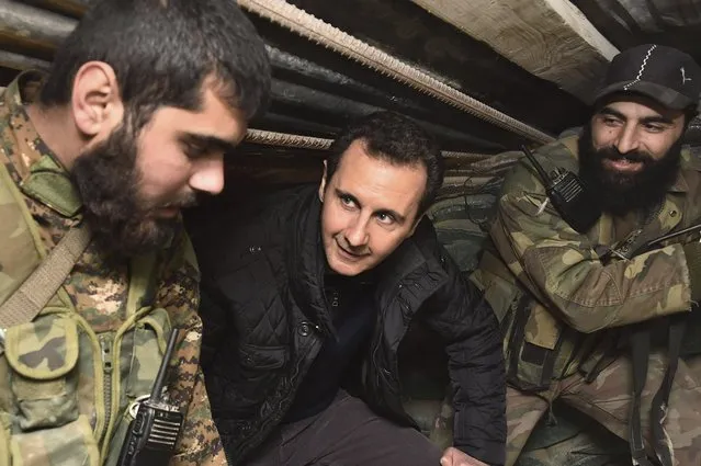 Syrian President Bashar al-Assad (C) talks to soldiers during a visit to Jobar, northeast of Damascus, in this handout photograph distributed by Syria's national news agency SANA on January 1, 2015. Al-Assad visited a district on the outskirts of Damascus and thanked soldiers fighting “in the face of terrorism”, his office said on its Twitter account on Wednesday, posting pictures of the rare trip. (Photo by Reuters/SANA)