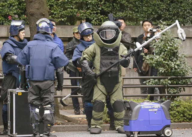 Members of a police bomb disposal squad wearing blast protection equipments prepare to work near the site of an explosion at the Yasukuni shrine in Tokyo, in this photo taken by Kyodo November 23, 2015. An apparent explosion at Japan's controversial Yasukuni Shrine for the war dead in Tokyo on Monday damaged the ceiling and the wall of a public bathroom near the south gate of the shrine, Kyodo news agency reported. (Photo by Reuters/Kyodo News)