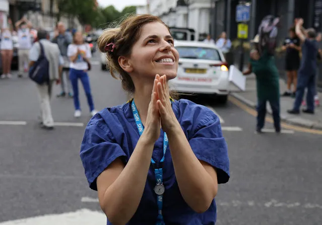 An NHS worker reacts at the Chelsea and Westminster Hospital during the Clap for our Carers campaign in support of the NHS, following the outbreak of the coronavirus disease (COVID-19), London, Britain, May 21, 2020. (Photo by Kevin Coombs/Reuters)