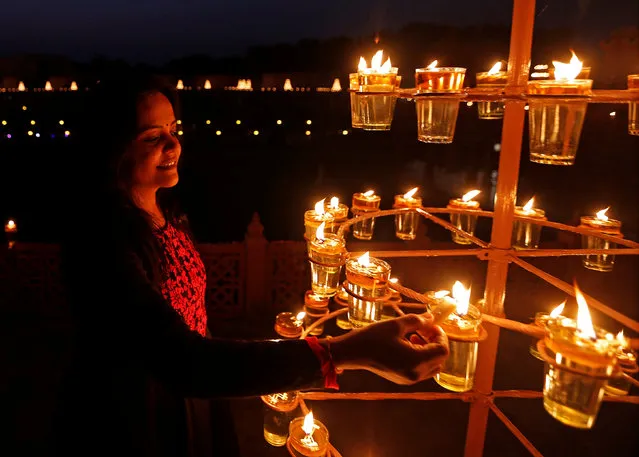 A devotee lights lamps at the Akshardham temple during celebrations on the eve of Diwali, the Hindu festival of lights, in Gandhinagar, India, October 29, 2016. (Photo by Amit Dave/Reuters)