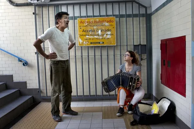 Jose Fister, 60, sings a tango as a street musician accompanies him with a bandoneon, in the entrance of a subway station in Buenos Aires, Argentina, Friday, January 16, 2015. (Photo by Rodrigo Abd/AP Photo)