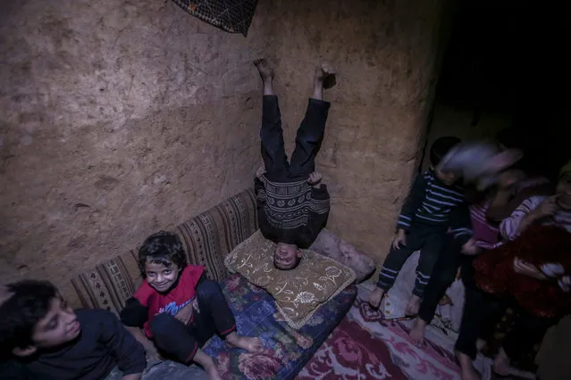 Syrian children play at an underground shelter in the rebel-held city of Douma, outskirts of Damascus, 31 October 2016. Abu Omar, 29, who used to work in construction before the Syrian war, says he dug the underground shelter under his kitchen by his own. He added some pieces of decoration to comfort those afraid of the airstrikes, including some dolls and teddy bears for the kids. Children at his neighborhood use the shelter during airstrikes. (Photo by Mohammed Badra/EPA)