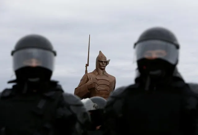 Law enforcement officers stand guard during a rally in support of jailed Russian opposition leader Alexei Navalny, as a monument dedicated to those who died during Russia's civil war after the 1917 Bolshevik revolution is seen in the background, in Stavropol, Russia on January 31, 2021. (Photo by Eduard Korniyenko/Reuters)