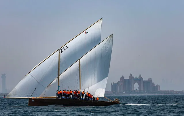 Crew of Namran dhow owned by Sheikh Zayed bin Hamdan bin Zayed Al Nahyan compete on their way to win the Al Gaffal Dhow Race, with Atlantis luxury hotel in the background outside Dubai, United Arab Emirates, 30 May 2023. Al Gaffal long distance Sur Bin Na'air 60ft Traditional Dhow Race, in a traditional Dhow boat, is the biggest traditional sailing race in the world. 125 boats take part in the race which starts from Sur Bu Na'air Island and reaches the finish line at the luxury hotel of Burj Al Arab in the coast of Dubai passing by Moon Island. The race was conceived by the late Sheikh Hamdan bin Rashid Al Maktoum and currently under patronage of the Crown Prince of Dubai H.H. Sheikh Hamdan Bin Mohammed Al Maktoum which is seeking to protect the heritage and the traditional marine sports. (Photo by Ali Haider/EPA)