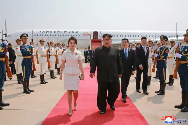 In this June 19, 2018, photo provided on June 20, 2018, by the North Korean government, North Korean leader Kim Jong Un, center right, and his wife Ri Sol Ju, center left, arrive at Beijing Capital International Airport in Beijing, China. Korean language watermark on image as provided by source reads: “KCNA” which is the abbreviation for Korean Central News Agency. (Photo by Korean Central News Agency/Korea News Service via AP Photo)