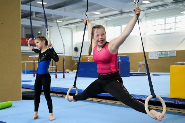 Annabelle, 13, and her sister Estelle, 10, both artistic gymnasts from Borna, hang from the rings during their training, ahead of the Special Olympics World Games Berlin 2023, the world's largest sports movement for people with intellectual disabilities, at the Federal base for competitive gymnastic artistics in Chemnitz, Germany on May 6, 2023. (Photo by Annegret Hilse/Reuters)