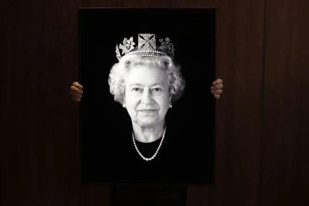Rob Munday, creator of the first officially commissioned 3D/holographic portrait of Britain's Queen Elizabeth II in 2004, unveils a previously unseen portrait of the monarch to celebrate the Platinum Jubilee, in London, Wednesday, May 4, 2022. The new portrait, which shows Queen Elizabeth II off-guard and smiling is named 'Platinum Queen: Felicity' and is dedicated to the 20 years of friendship between The Queen and her personal assistant and close friend Miss Angela Kelly. (Photo by Kirsty Wigglesworth/AP Photo)