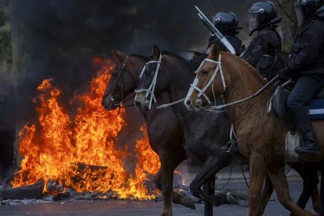 Mounted police charge during clashes with demonstrators in San Salvador de Jujuy, Argentina, Tuesday, June 20, 2023. The protests have erupted throughout Jujuy province in response to a recently approved provincial constitutional reform that critics argue restricts the rights of social protest. (Photo by Javier Corbalan/AP Photo)