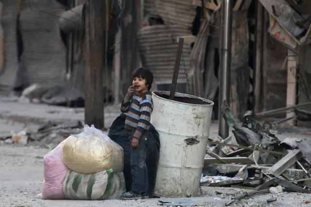 A boy stands amid the damage in the rebel-held besieged al-Shaar neighborhood of Aleppo, Syria November 23, 2016. (Photo by Abdalrhman Ismail/Reuters)