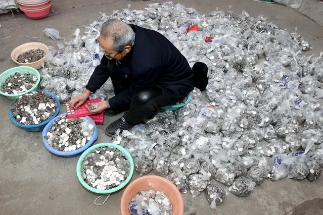 A man counts coins collected from coin-operated laundry machines, at a warehouse in Zhengzhou, Henan province, China, January 11, 2016. A man running a coin-operated laundromat service had failed to exchange 300,000 yuan ($45,609) worth of coins into banknotes to pay his employees 3 months worth of salaries, according to local media. Local banks said they are unable to process the exchange in a go, the reports added. (Photo by Reuters/Stringer)