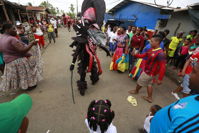 A man dressed in a devil costume confronts a reveler during the Devils and Congos carnival ritual, in Nombre de Dios, Panama, Wednesday, February 18, 2015. The Ash Wednesday ritual involves “devils” dancing through the streets in the guise of looking for and scaring “sinners” among the merry residents who have been partying for four days. (Photo by Arnulfo Franco/AP Photo)